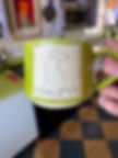 Green handmade ceramic mug with a hand‑drawn dog sitting in the grass
