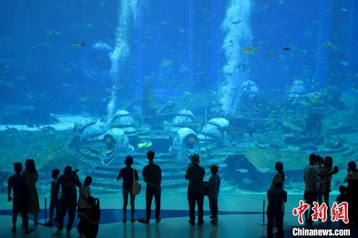La imagen muestra a los turistas viendo el "Mundo submarino" en el Hotel Atlantis en Sanya, Hainan. Foto de Luo Yunfei
