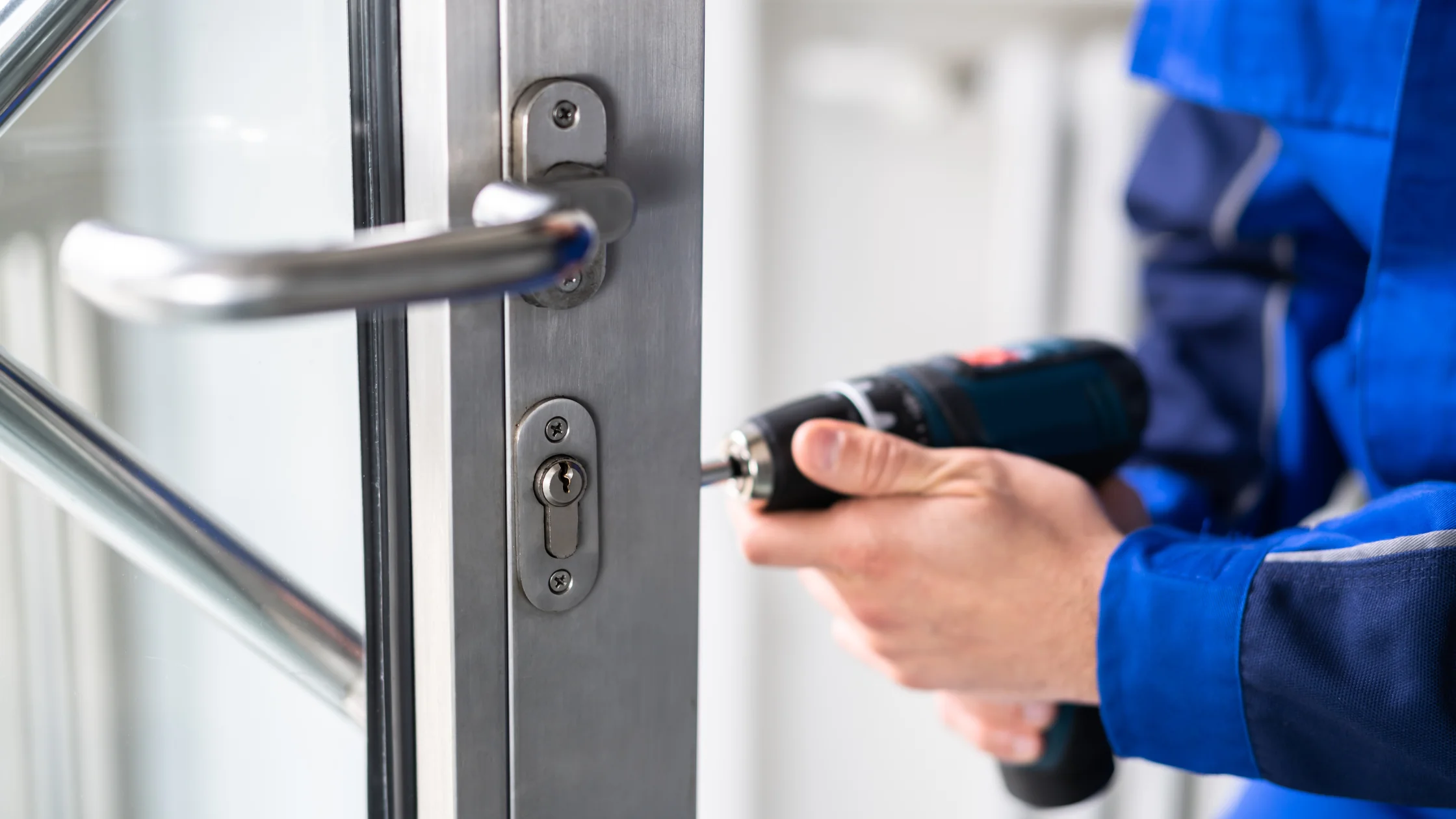 Teamwork Locksmith Inc. technician servicing a commercial-grade door lock at a business premises.