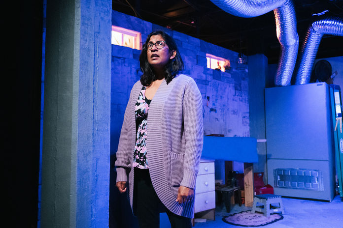 A woman stands slightly off-center of the frame.