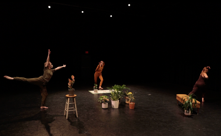 Several women dance in separate sections of a stage, demonstrating the distance felt during Covid.