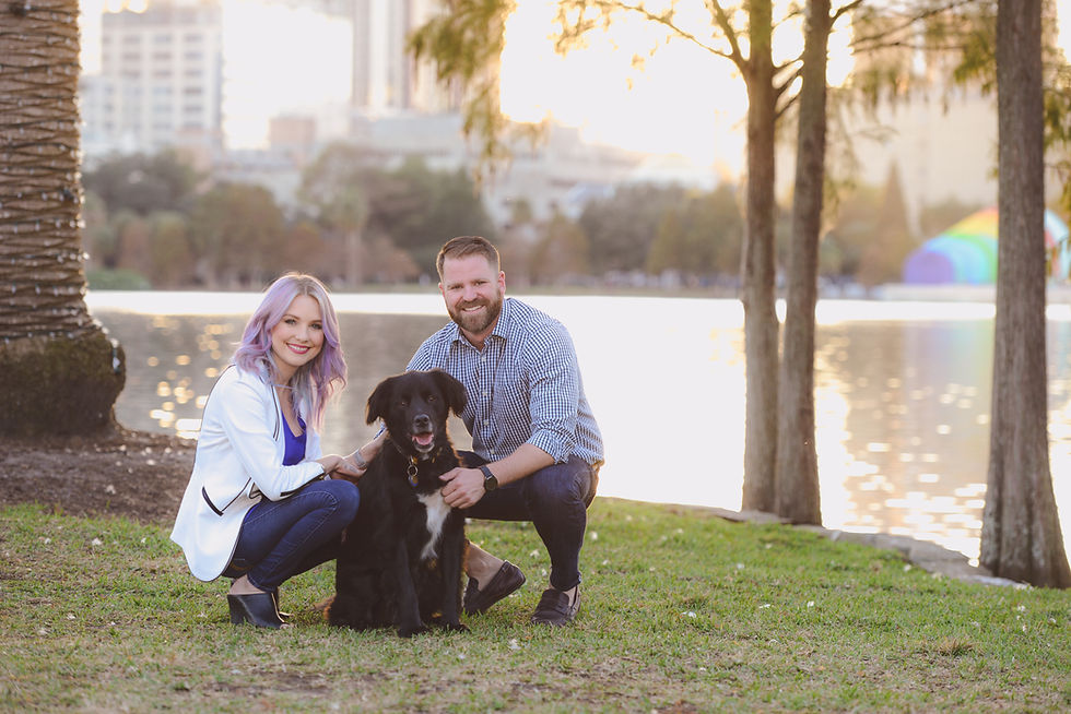 couple poses with their dog at Lake Eola in Downtown Orlando