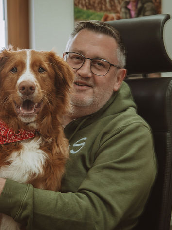 Bürohund und Herrchen. Portrait auf Bürostuhl.