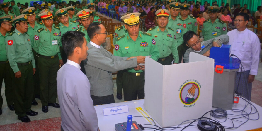 Myanmar officers inspecting the voting system