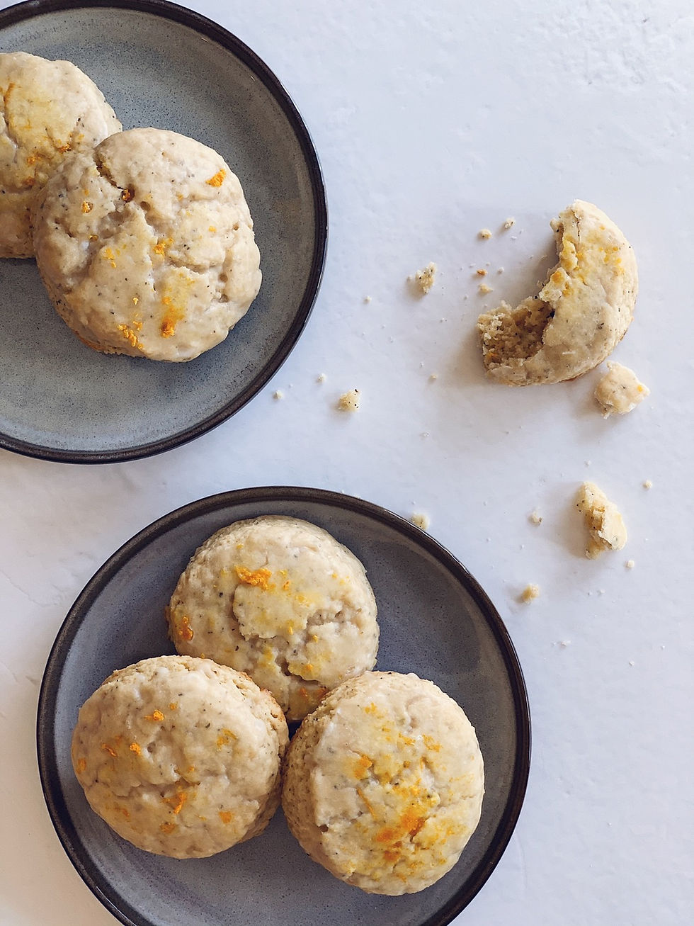 Glazed scones, plated and crumbled with orange zest