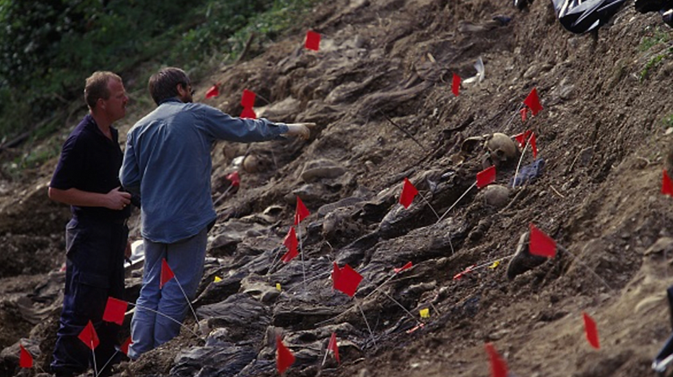 Authorities stand by a mass grave exhumation site near Srebrenica, Bosnia and Herzegovina [File: Laurent Van der Stockt/ Getty Images]