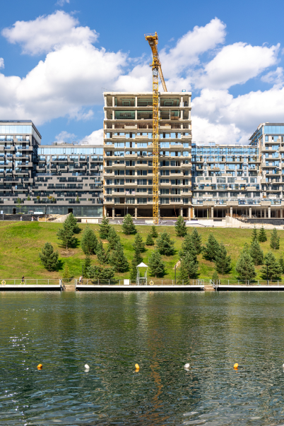 construction-crane-modern-residential-complex-near-water-new-housing-by-lake 1