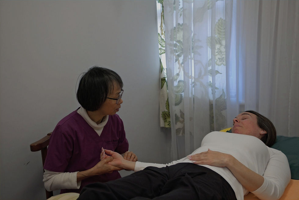 Rachael Lau checking a patient's pulse during a consultation