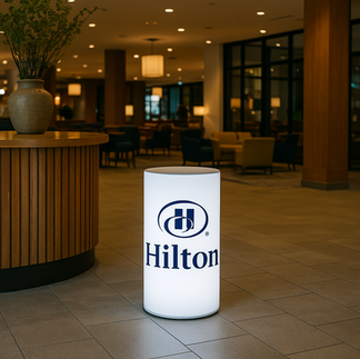Branded cylinder lightbox in a hotel lobby showcasing a brand logo