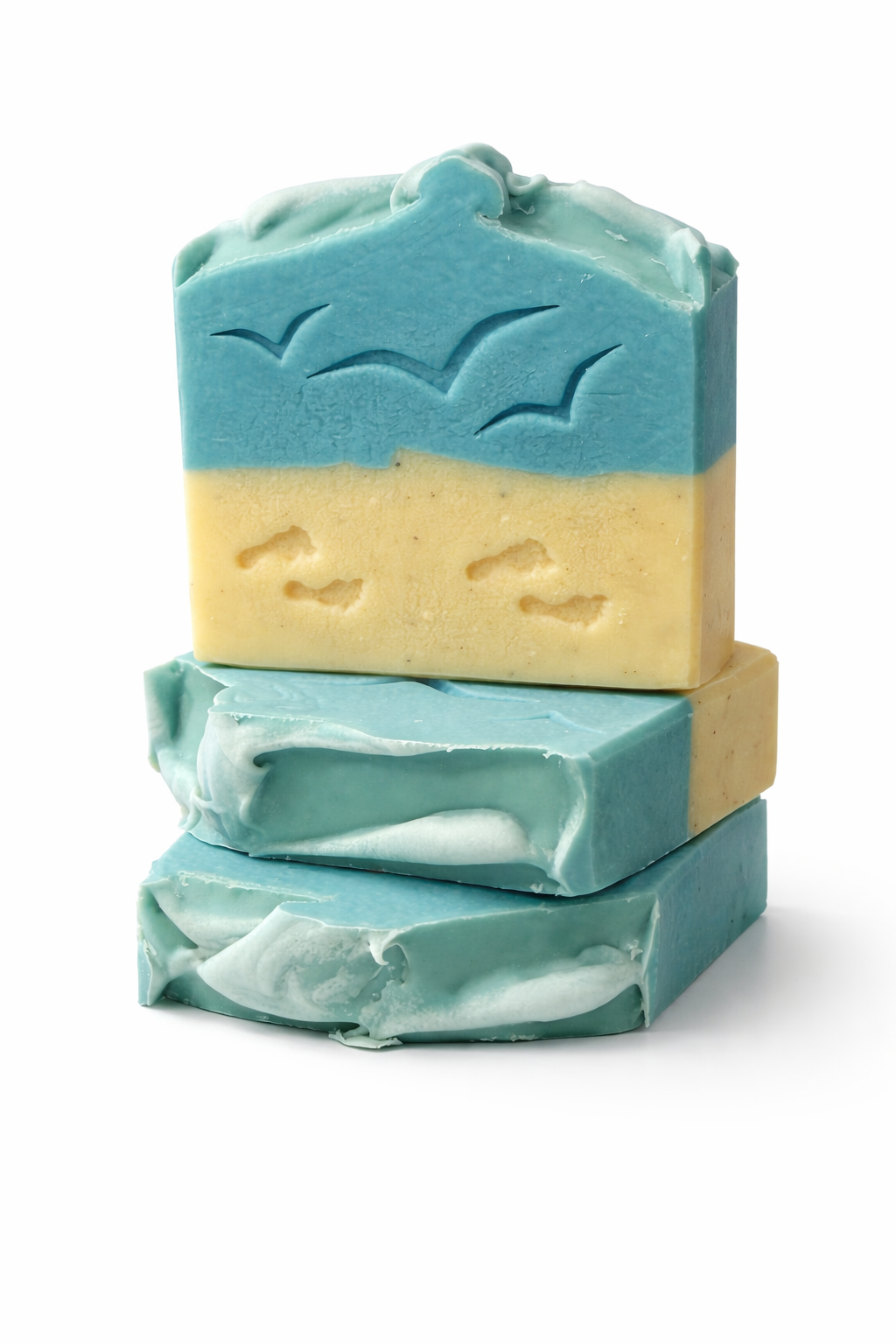 Handmade ocean-inspired soap bar with blue and sandy layers and bird imprints on top, styled in a clean commercial product