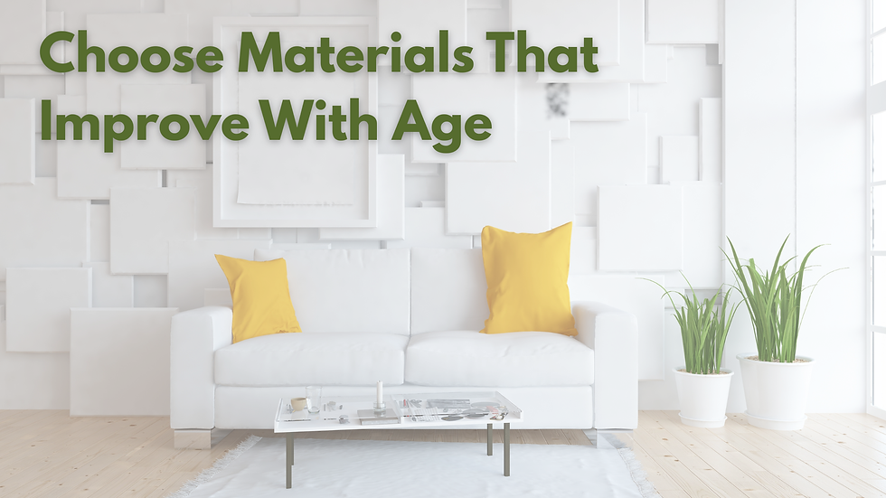 White room with a sofa featuring yellow pillows, plants, a table, and wall art. Green text reads "Choose Materials That Improve With Age."