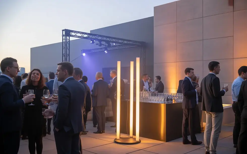 Vignette photoréaliste ESTELLE SYMFONIA : soirée d’entreprise premium sur rooftop moderne, invités business chic discutant avec verres, colonnes LED et éclairage architectural bleu nuit/violet, bar cocktail design sans logo.