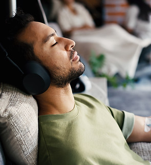 Man, sleep and iv drip with headphones for healthcare, iron infusion or immune booster in
