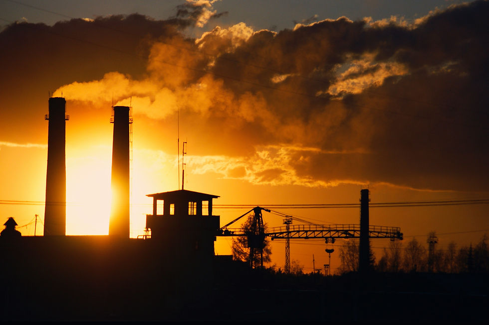 Décarboner l'industrie : silhouette d'une usine au coucher du soleil, illustrant les enjeux liés à la chaleur industrielle et à la transition énergétique.