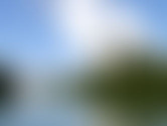 Centrale nucléaire du Bugey au bord du Rhône, avec plusieurs tours de refroidissement rejetant de la vapeur d’eau, entourée de végétation.