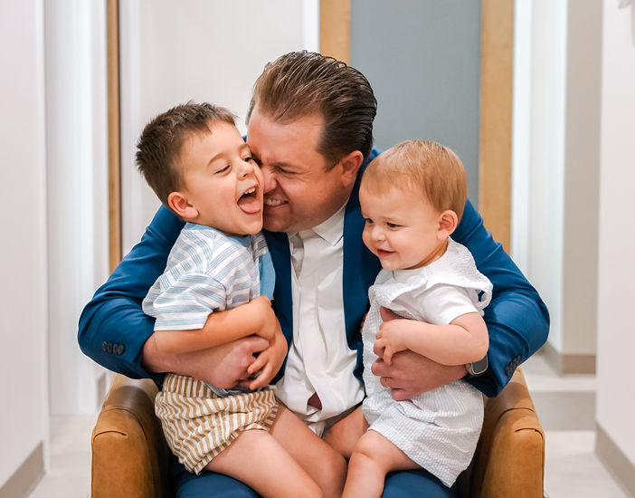 Parents and child cuddling together during a candid family portrait.