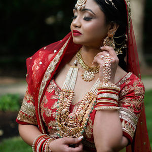 Cultural portrait of a woman wearing a vibrant red traditional outfit.