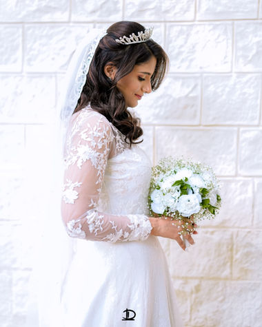 Bride holding an elegant flower bouquet before walking down the aisle