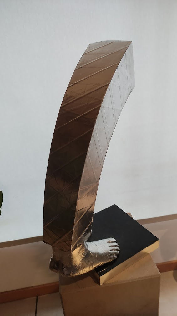 Miniaturbild: Escultura de bronze curvada, moderna, sobre pedestal de madeira.