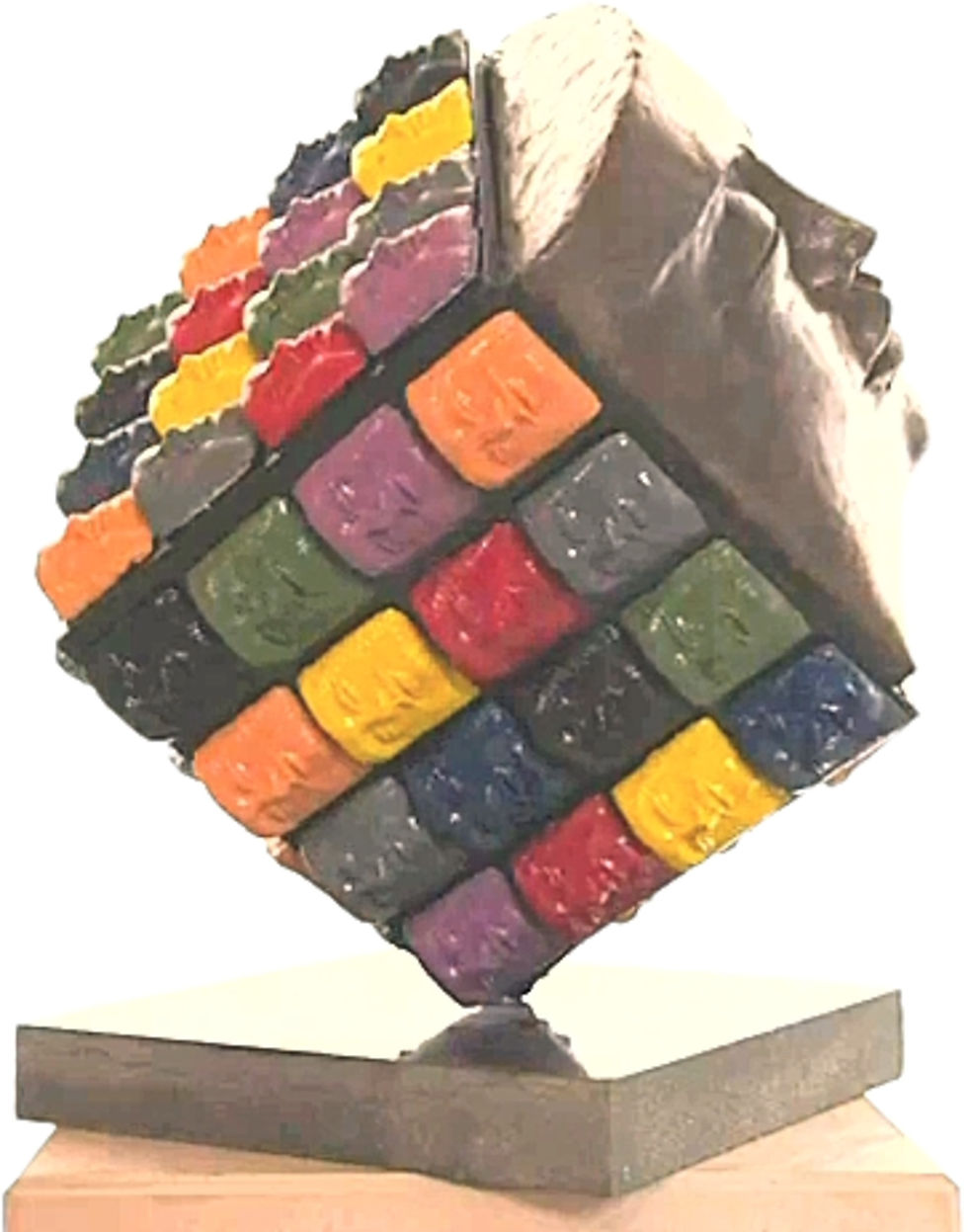 Miniaturbild: Escultura de cubo Rubik colorido e texturizado sobre uma base de madeira.