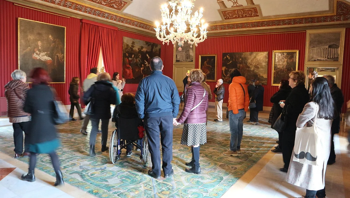 Gruppo di partecipanti ad una visita guidata a Palazzo Arcivescovile, organizzata da TACUS, intenti ad ascoltare la spiegazione