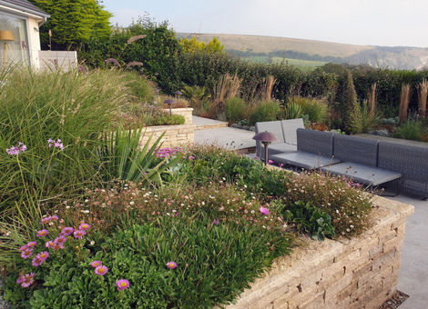 Decking and coastal planting in cliff top garden overlooking Swanage Bay on the dorset coast designed by Melanie Driver Landscape and Garden design