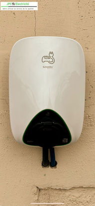 Installation d'une borne de recharge pour véhicule électrique sur un mur.