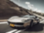 A sleek supercar races down a winding road, capturing the thrill of speed and precision.