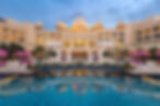The Fairmont Udaipur Palace stands majestically against the evening sky.