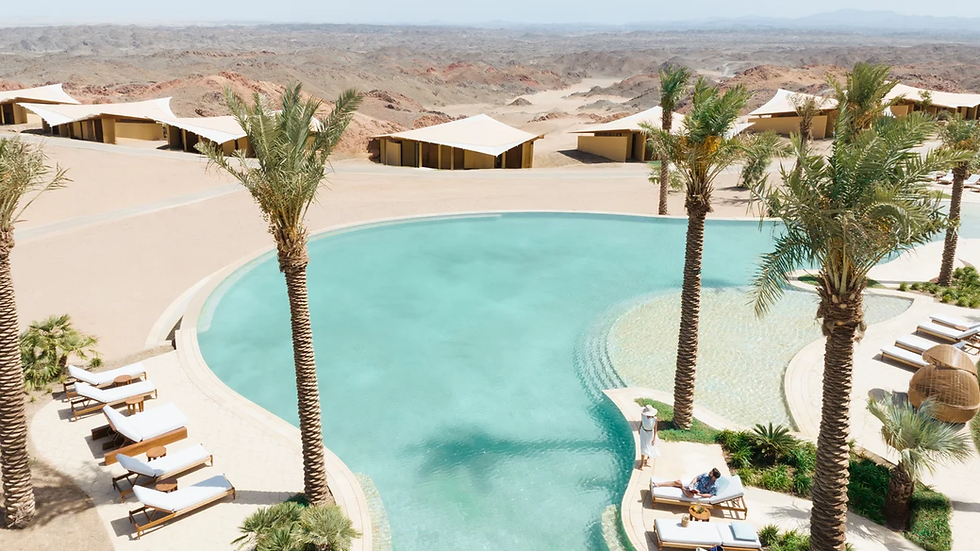 Luxurious oasis at Six Senses Southern Dunes, with a serene pool surrounded by palm trees and desert views.
