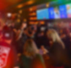 Guests enjoying food and drinks at the lively bar area inside The Uncommon in Downtown Chandler