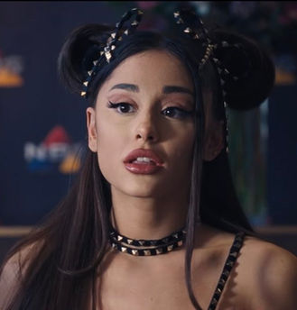 Still image from Netflix film Don't Look Up featuring Riley Bina, a girl with her hair done up in bow-like pigtails and accessorized with studs
