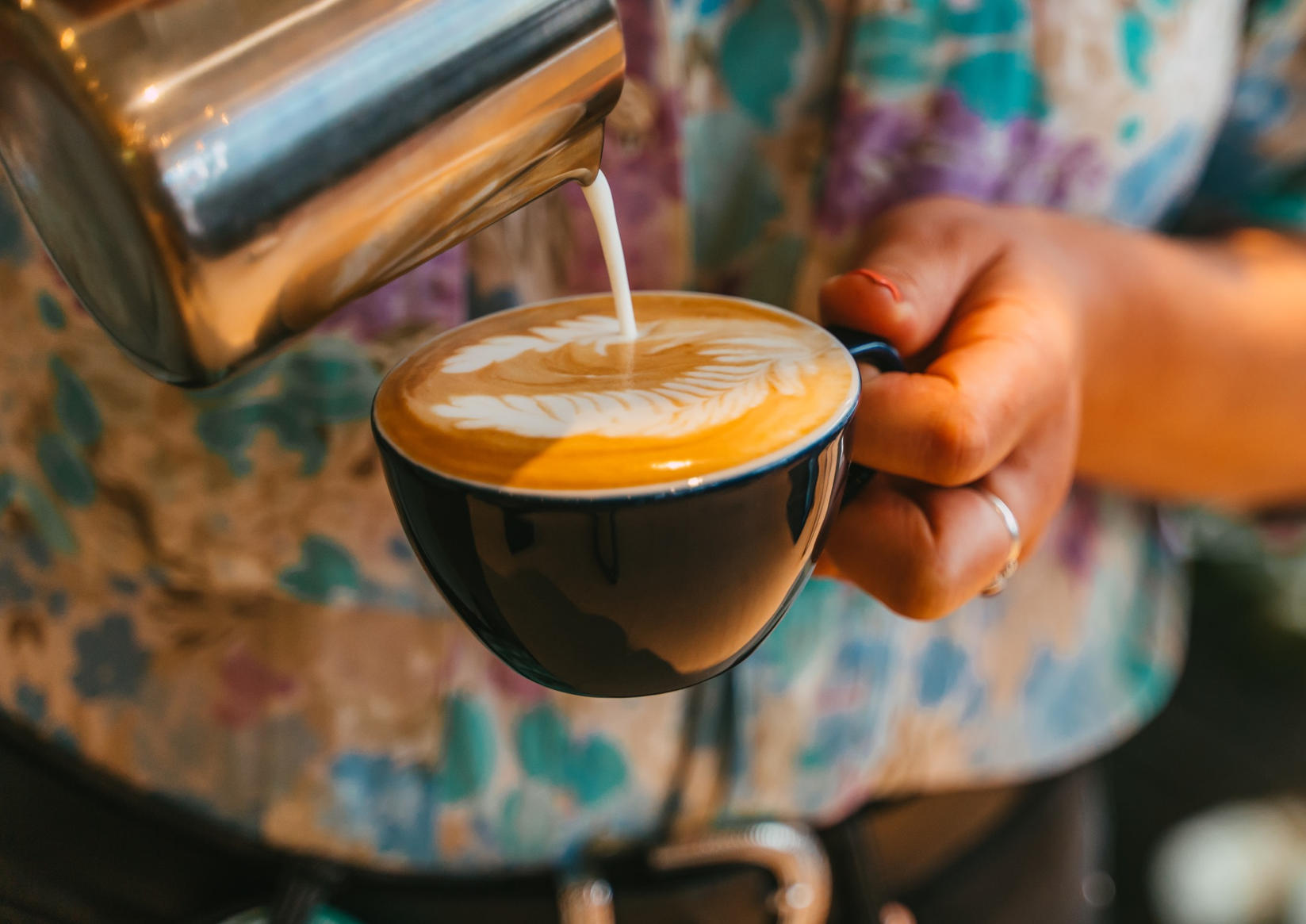 Foto van melk schenken, het maken van een capuccino