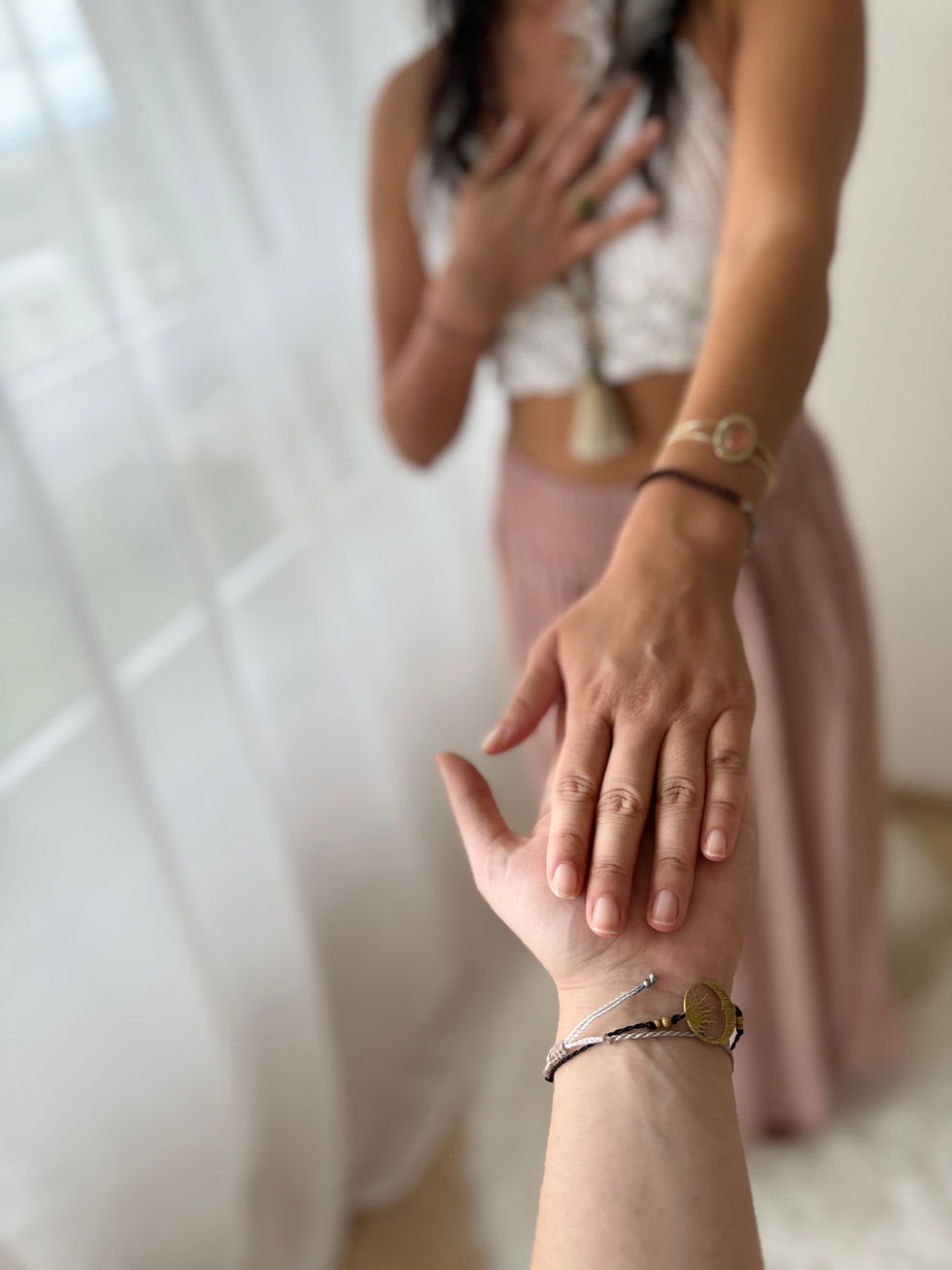 Sabrina legt sich die Hand aufs Herz, während eine andere Person ihre Hand hält – Symbol für Heilung, innere Kind Arbeit und emotionale Verbindung