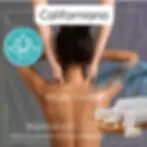 Donna sdraiata a pancia in giù che riceve un massaggio californiano sulla schiena, con mani dell’operatore che scorrono delic