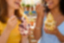 Two smiling women eating frozen yogurt