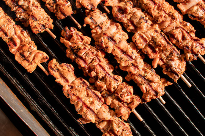 Chicken Souvlaki skewers lined up on a hot grill