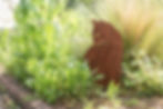 Giardino fiorito con graminacee e scultura di gatto