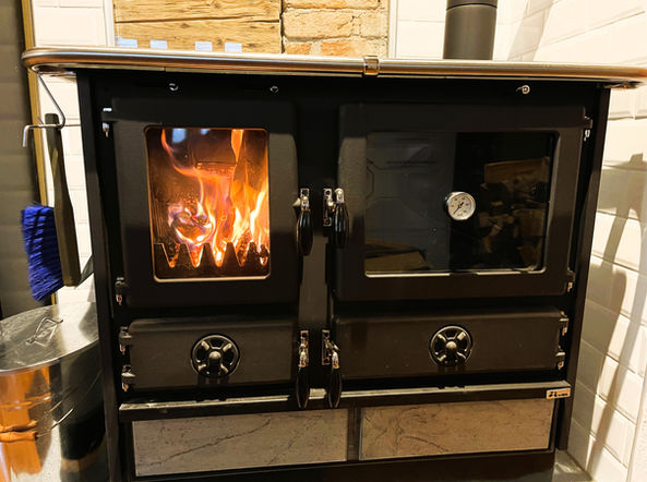 Der Schweden-Holzofen mit Feuerfenster verbreitet nicht nur knisternde Wärme , sondern auch kulinarische Gerüche, wenn Du ihn auch zum Kochen verwendest! Du kannst Dein Feuerholz in einer geschützten Holzlade vor dem Eingang lagern.