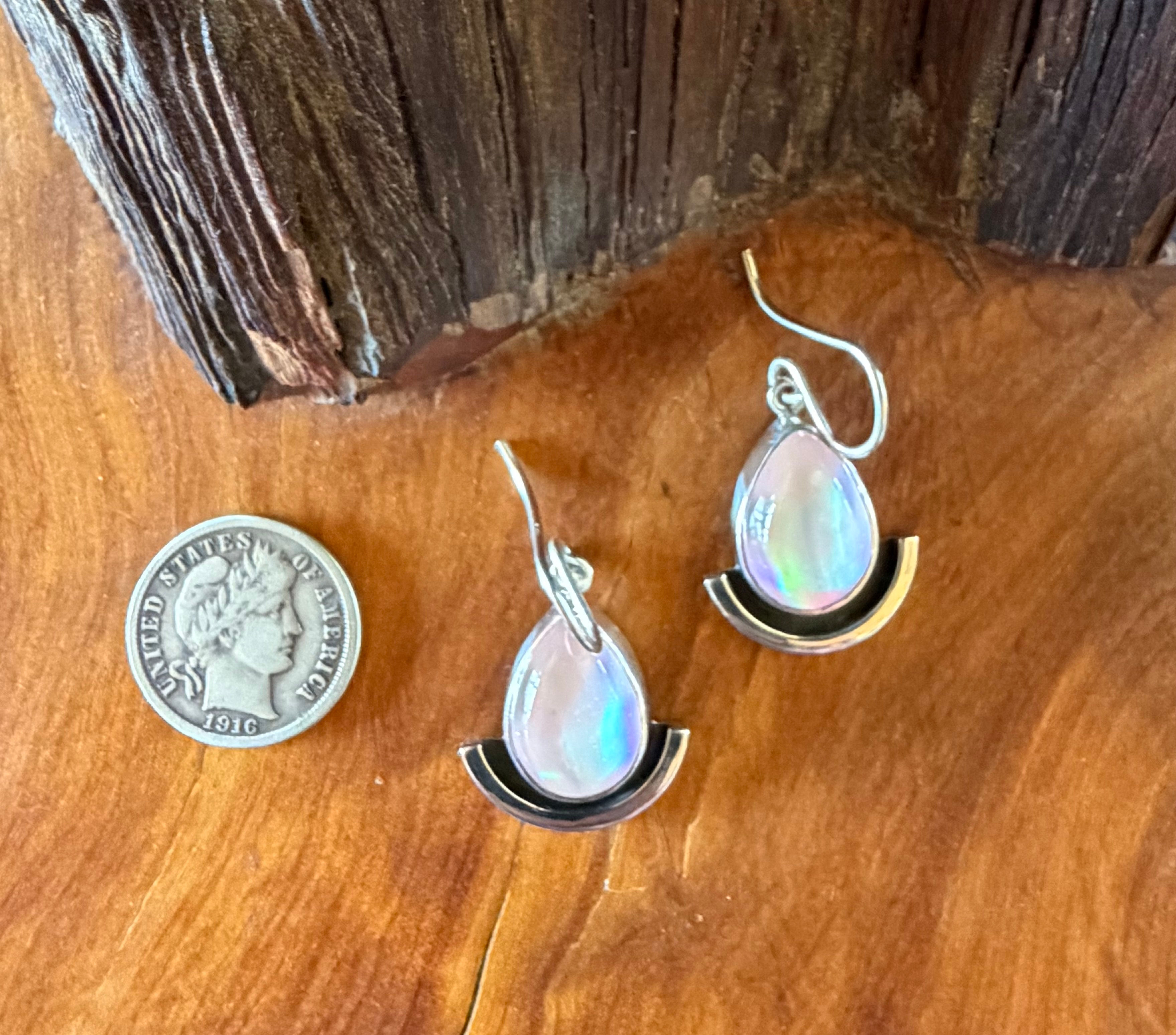 Hand-fabricated sterling silver aura opal earrings, iridescent pink teardrop stones above hammered crescent