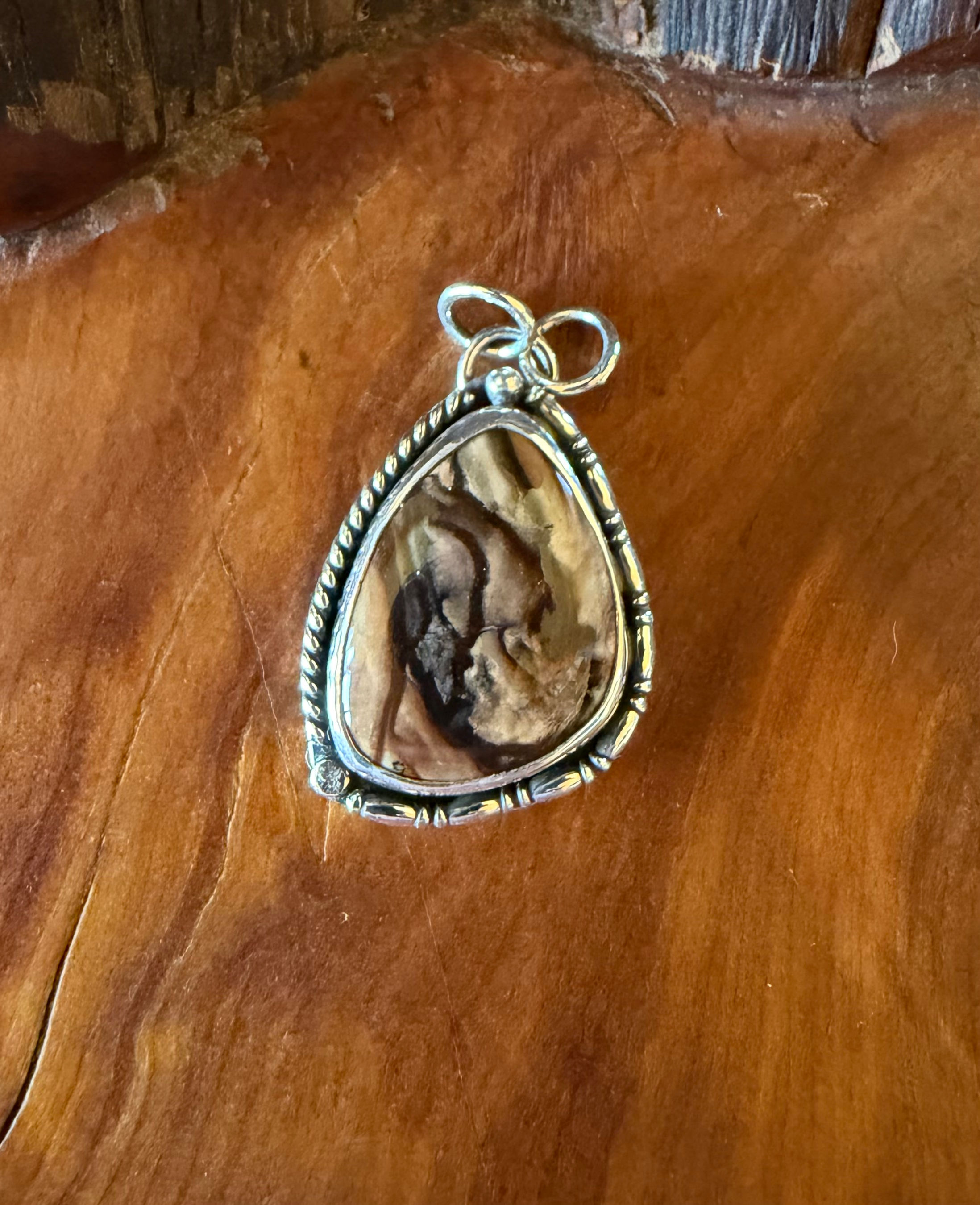 Oregon Deschutes jasper freeform pendant, warm amber russet stone, twisted rope border, handcrafted Taos, New Mexico