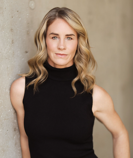 Andrea Ross, stunt performer and TEDx speaker, headshot against a concrete wall