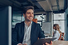 smiling-man-in-office-holding-clipboard-modern-wo-2026-01-09-07-49-58-utc.jpg