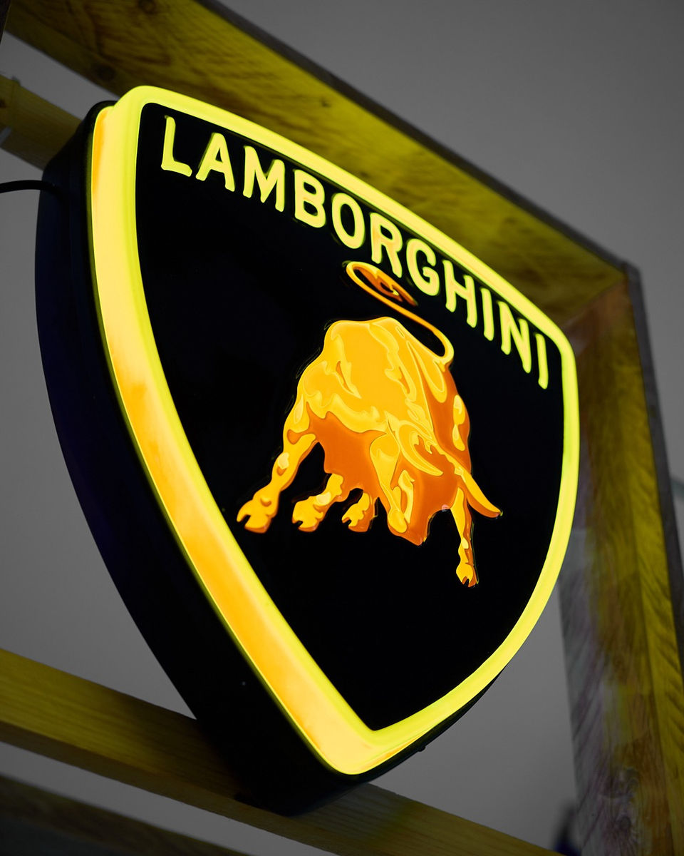 insegna a neon termoformata lamborghini in ottime condizioni conservative, 
 è un'icona di prestigio, potenza e stile nel mondo dell'automobilismo di lusso. Un'insegna che cattura lo spirito audace e innovativo della casa automobilistica italiana, con un design che riflette la sua eredità leggendaria e il suo status di marchio di élite. Posizionata all'ingresso di uno showroom Lamborghini.