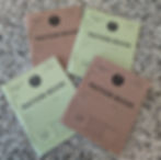 Four 1941 ration books on a speckled surface, two green and two brown, labeled "MINISTRY OF FOOD." Text fields for address details.