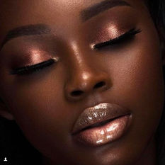 African American woman with shimmer eye shadow and lipgloss.