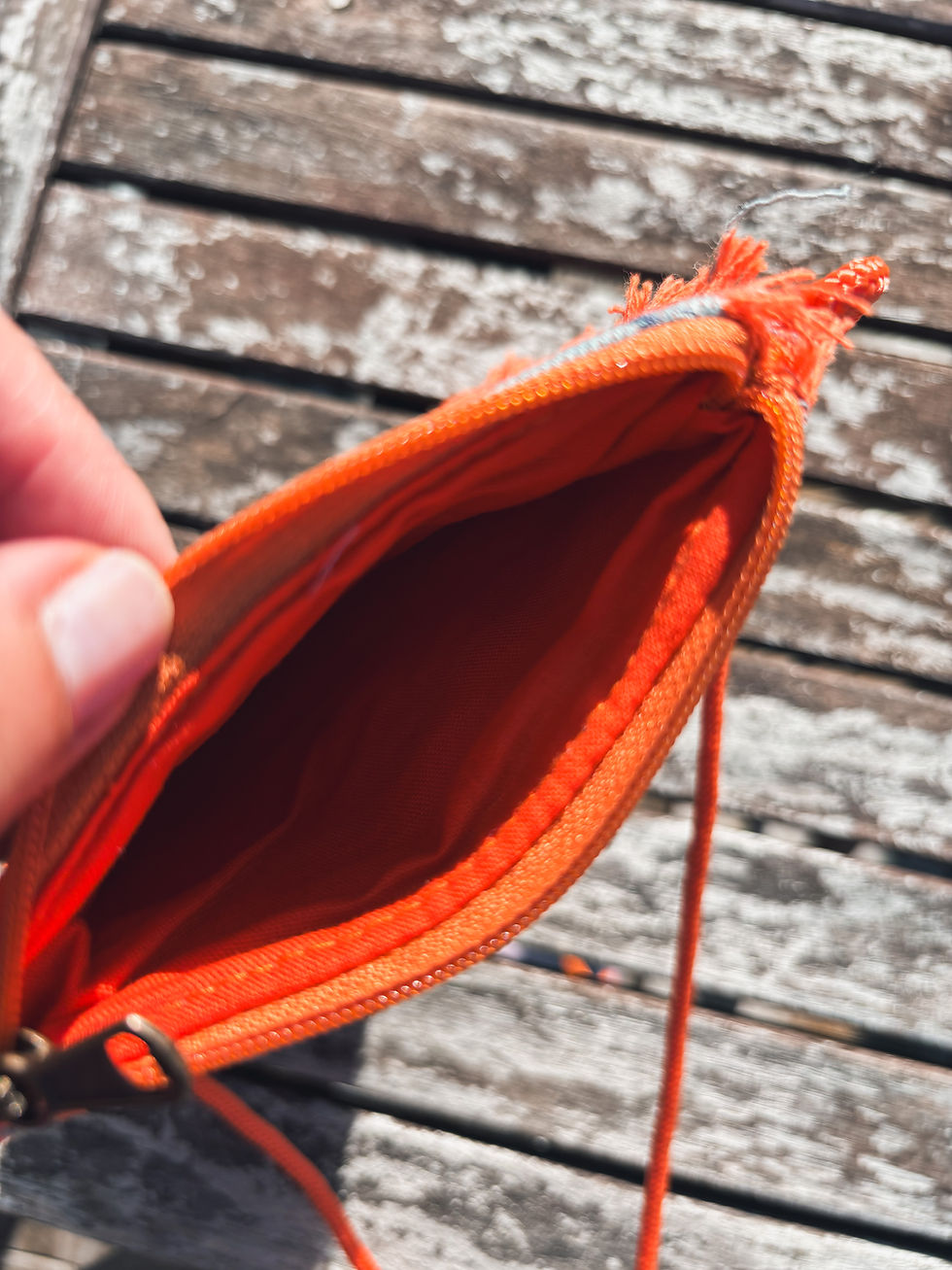 Thumbnail: Man sieht das orange Innenfutter der Handytasche.