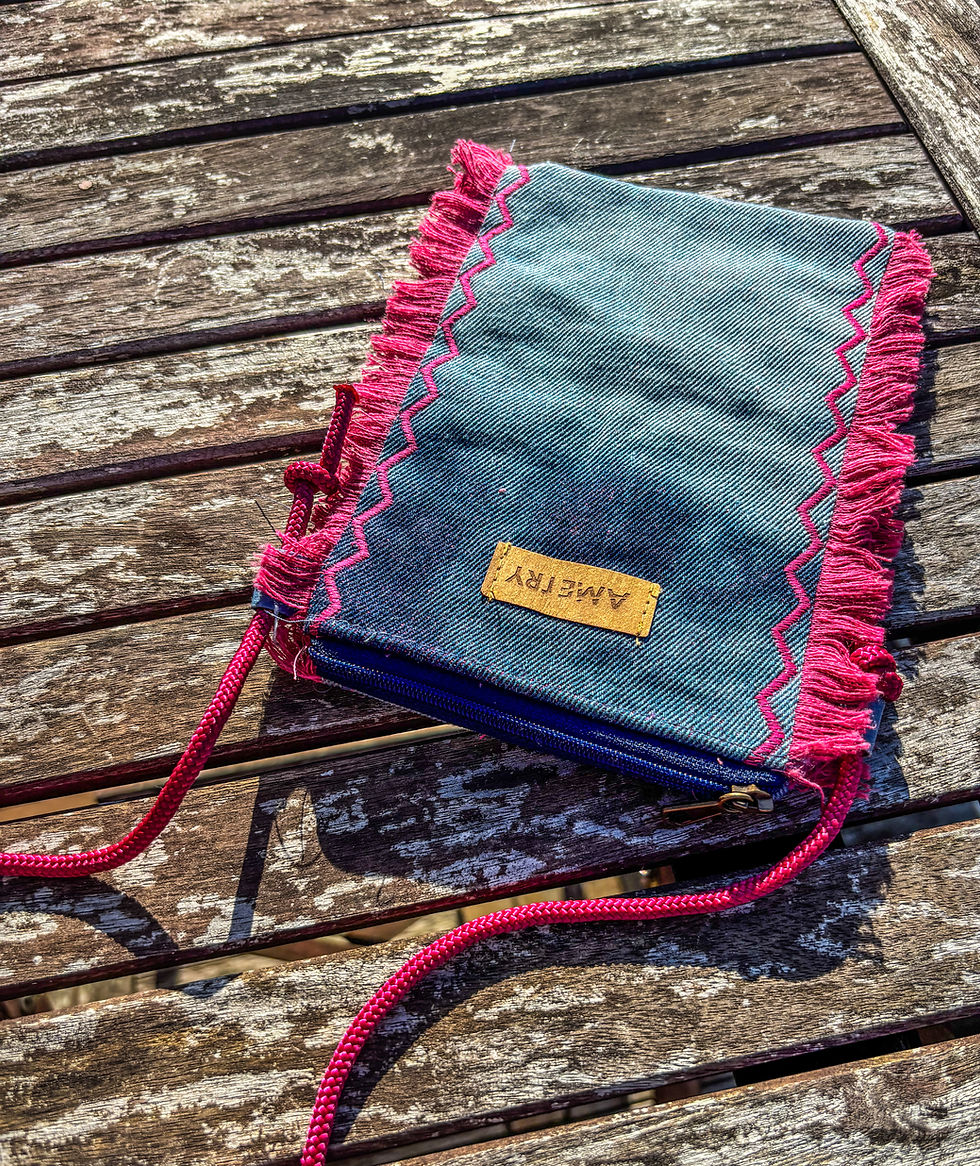 Thumbnail: Handy Tasche aus Jeans liegt auf einem braunen Tisch.