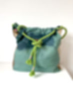 Eine große Tragetasche mit grünem und blauem Batikmuster. Die Tasche hat einen Kordelzugverschluss mit einem hellgrünen Seilg