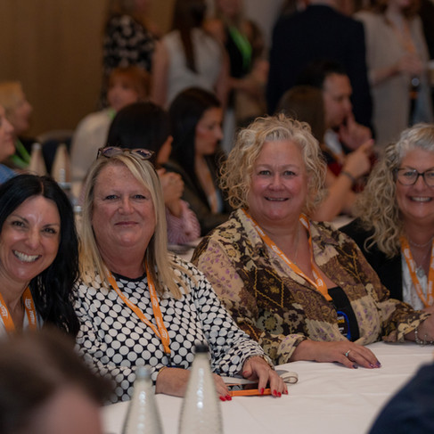 Luxury Dream Holidays travel consultants seated together during a Hays Travel Independence Group conference session, wearing lanyards and listening to industry presentations.